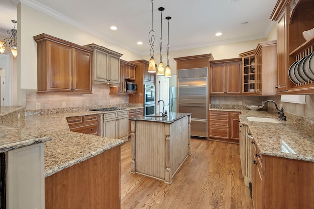 kitchen with light stone counters, a sink, appliances with stainless steel finishes, light wood-type flooring, and crown molding