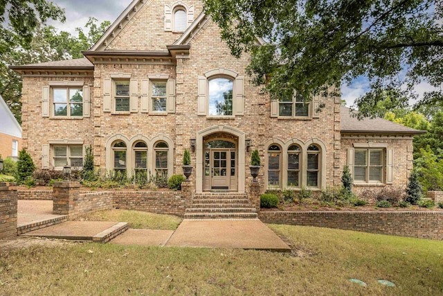 view of front of property with brick siding and a front lawn