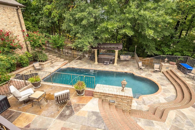 view of swimming pool featuring a patio area, a hot tub, fence, and a fenced in pool