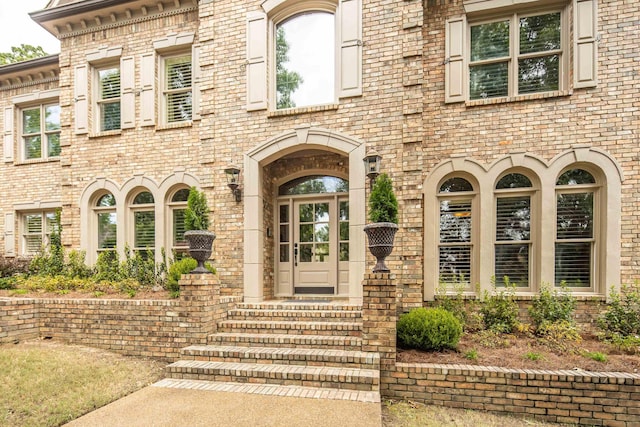 doorway to property featuring brick siding