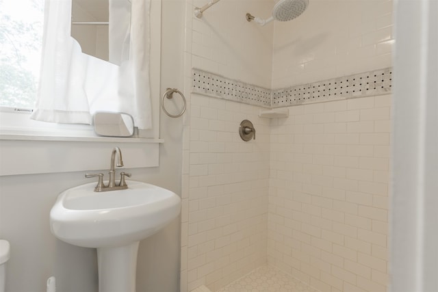 bathroom featuring sink and a tile shower