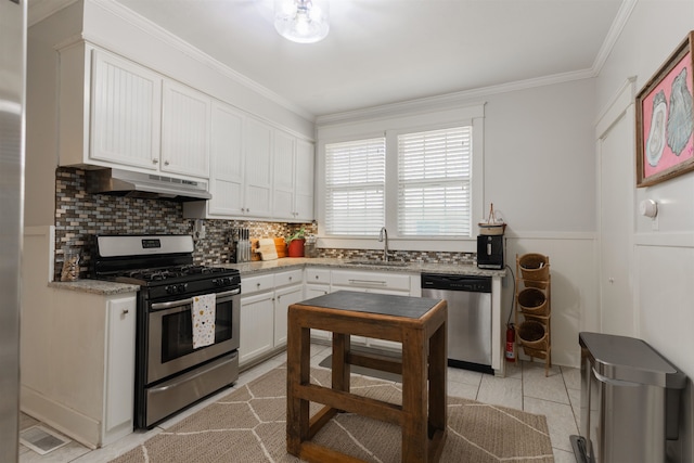 kitchen with white cabinets, sink, backsplash, appliances with stainless steel finishes, and crown molding