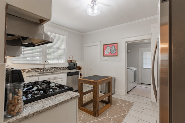 kitchen featuring separate washer and dryer, sink, stainless steel appliances, and plenty of natural light