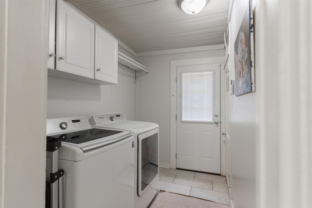 laundry area featuring cabinets, light tile patterned floors, and washing machine and dryer