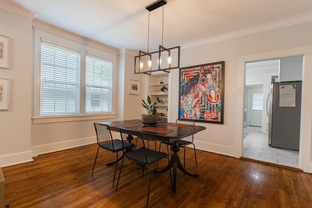 dining area with wood-type flooring, a notable chandelier, and crown molding