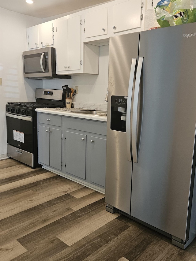 324 Harrell St, Memphis, TN 38112 - kitchen with stainless steel appliances, dark wood-style floors, light countertops, white cabinets, and gray cabinetry