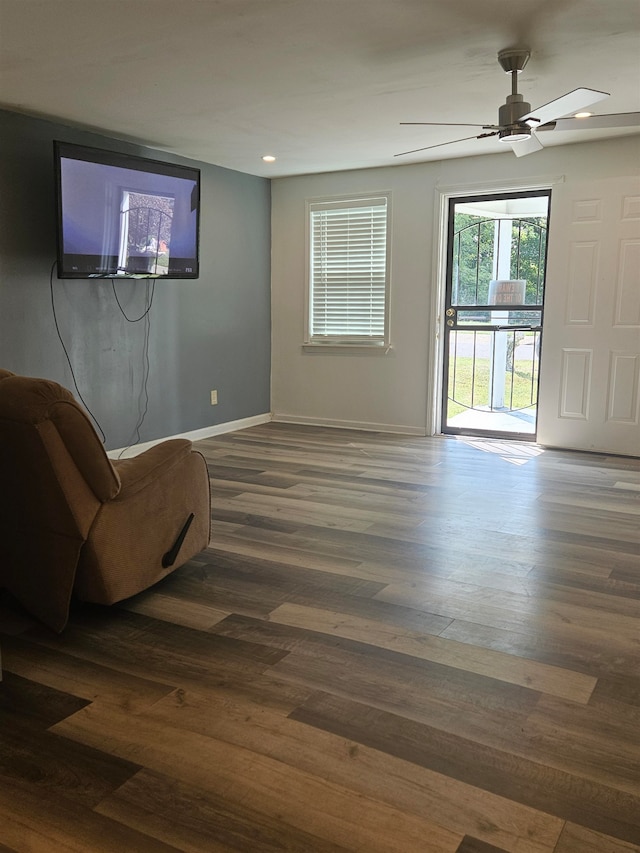 living room featuring dark wood-type flooring and ceiling fan