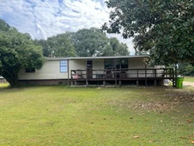 view of front of home with a deck and a front lawn