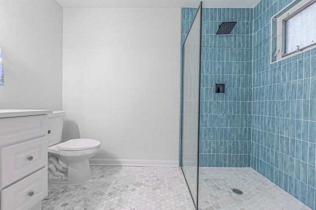 bathroom with vanity, toilet, tiled shower, and a textured ceiling