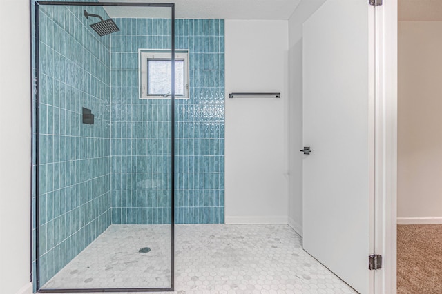 bathroom featuring tiled shower and a textured ceiling