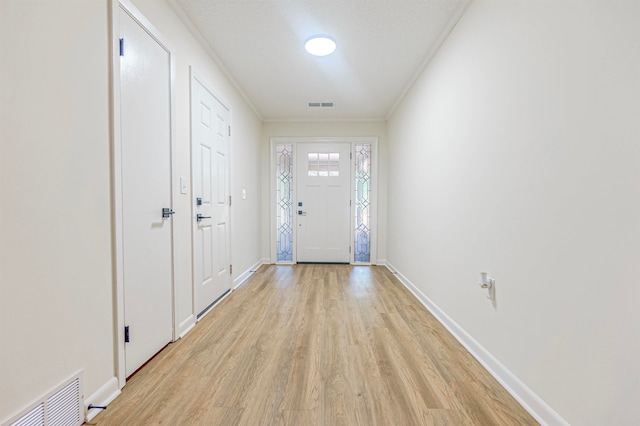 entryway featuring crown molding and light hardwood / wood-style flooring