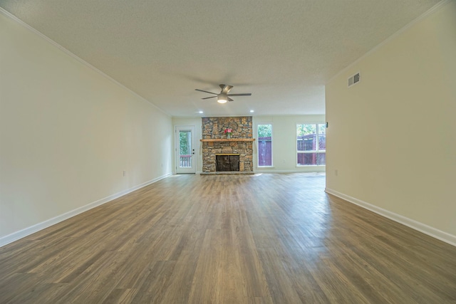 unfurnished living room featuring ceiling fan, dark hardwood / wood-style floors, and a stone fireplace