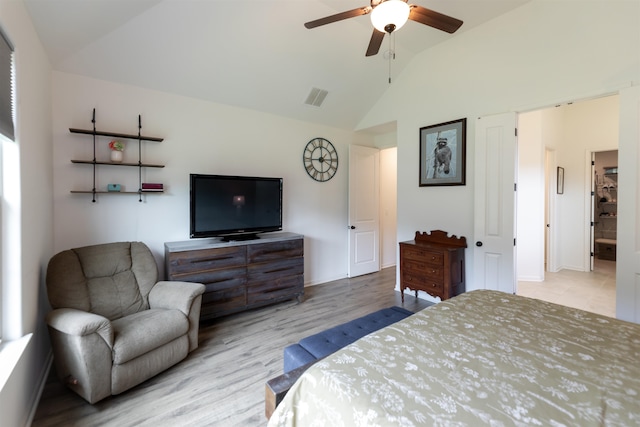 bedroom featuring lofted ceiling, ceiling fan, light wood-type flooring, and connected bathroom