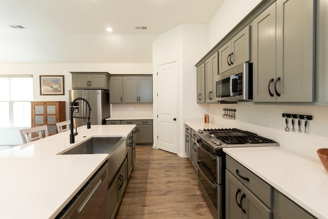 kitchen featuring gray cabinetry, hardwood / wood-style flooring, and stainless steel appliances