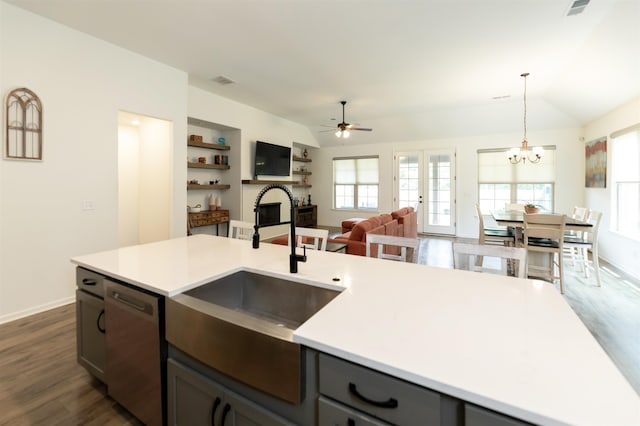 kitchen featuring ceiling fan with notable chandelier, sink, hanging light fixtures, vaulted ceiling, and stainless steel dishwasher