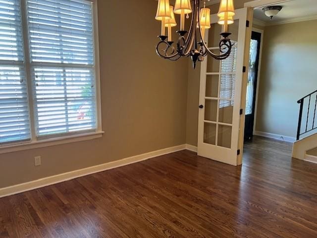 unfurnished dining area with ornamental molding, dark wood-type flooring, and an inviting chandelier