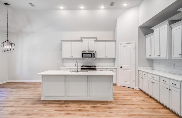 kitchen with visible vents, appliances with stainless steel finishes, light countertops, and a sink