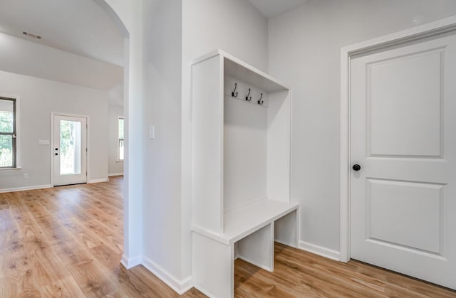 mudroom featuring arched walkways, visible vents, light wood-style flooring, and baseboards