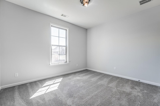 carpeted empty room with visible vents and baseboards