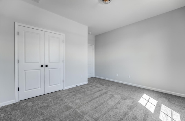 unfurnished bedroom with carpet, baseboards, and a closet