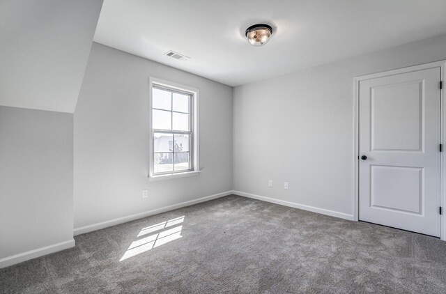 empty room featuring carpet flooring and vaulted ceiling