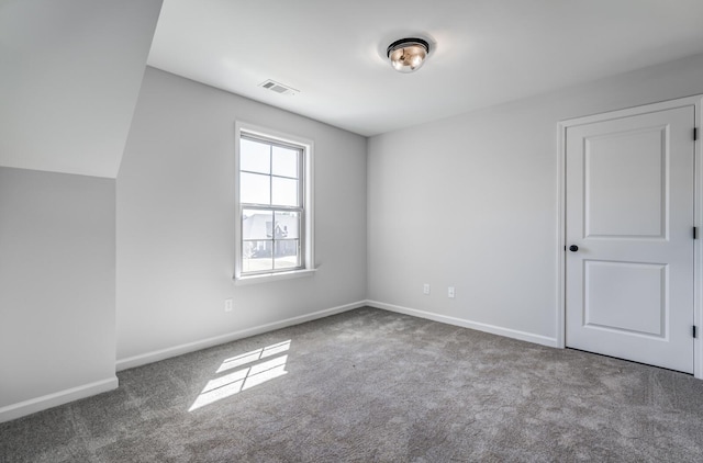 empty room with carpet flooring, baseboards, and visible vents