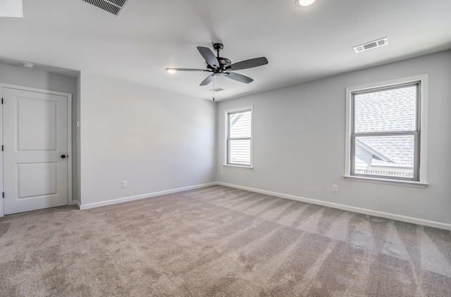 spare room with visible vents, a ceiling fan, baseboards, and carpet floors