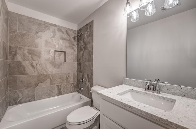 full bathroom with tiled shower / bath, vanity, and toilet