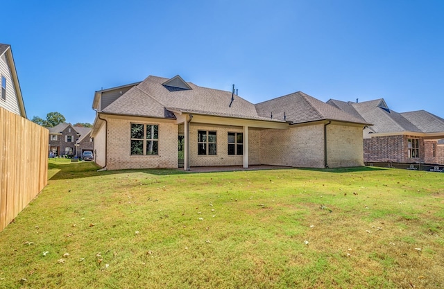 rear view of property with a patio area and a lawn