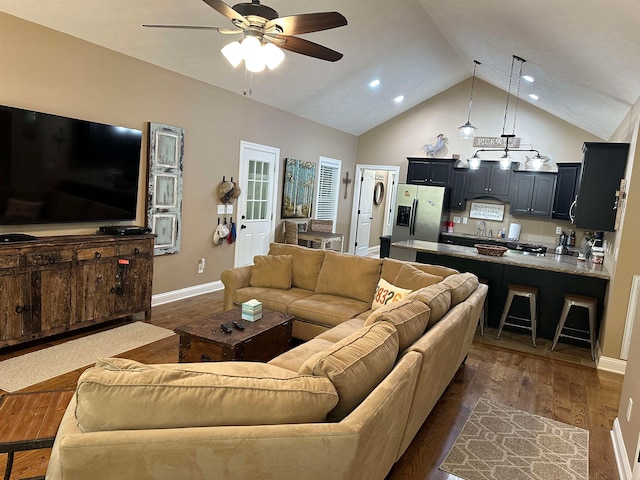 living room featuring vaulted ceiling, dark hardwood / wood-style floors, sink, and ceiling fan