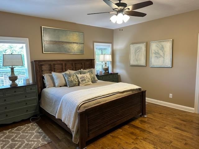 bedroom with dark hardwood / wood-style flooring and ceiling fan