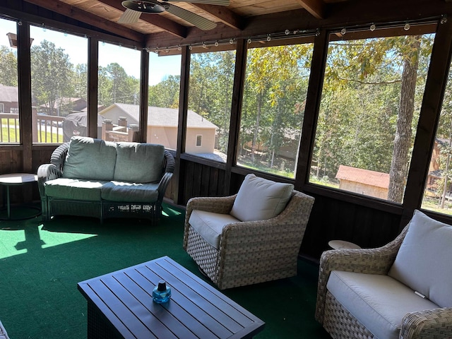 sunroom featuring wooden ceiling, beamed ceiling, a healthy amount of sunlight, and ceiling fan