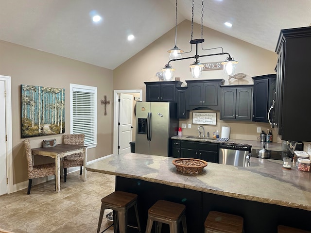 kitchen featuring a breakfast bar area, pendant lighting, appliances with stainless steel finishes, sink, and high vaulted ceiling