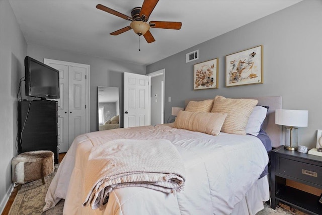 bedroom with a closet, visible vents, and ceiling fan