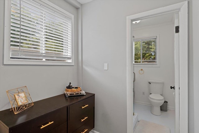 bathroom with baseboards, toilet, and ornamental molding