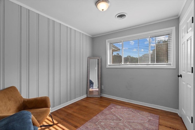 sitting room featuring wood-type flooring and ornamental molding