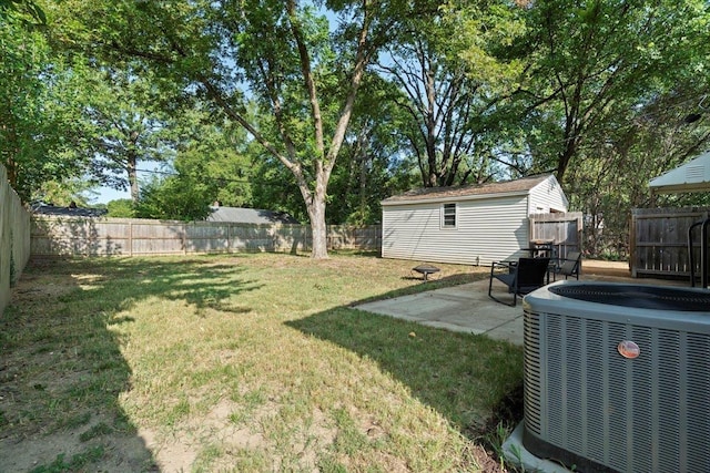 view of yard with a patio area, cooling unit, an outbuilding, and a fenced backyard