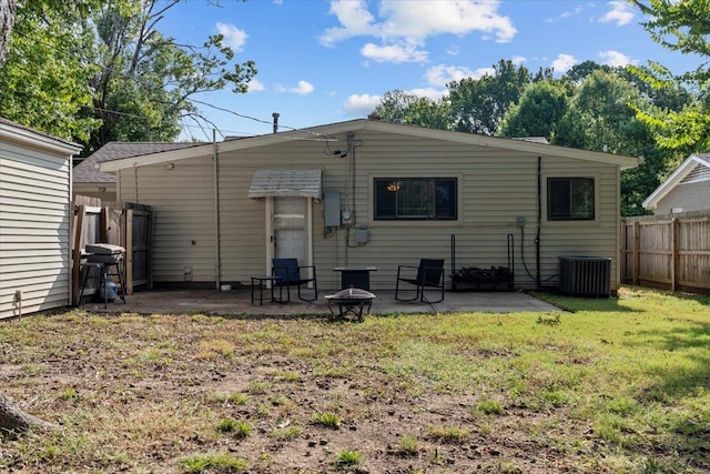 back of property with a patio, a yard, an outdoor fire pit, and cooling unit