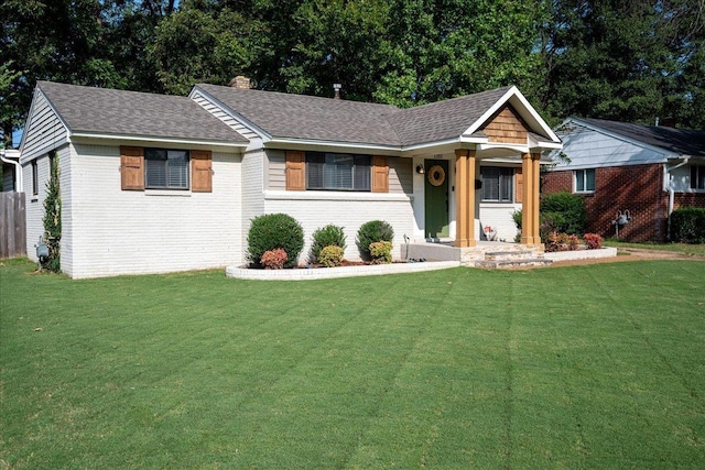 ranch-style house with a front yard and brick siding