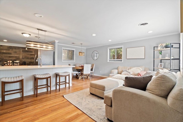 living room featuring wood walls, light wood-type flooring, and crown molding