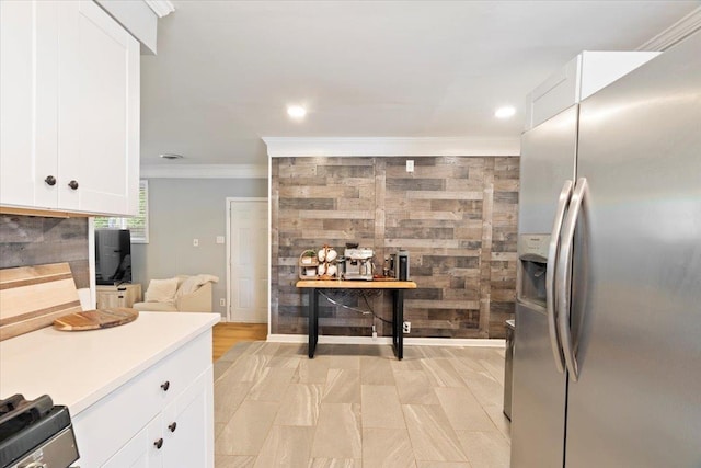 kitchen with ornamental molding, backsplash, white cabinetry, stainless steel fridge, and light countertops