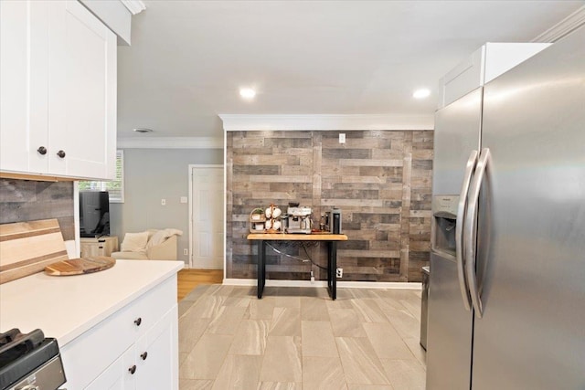 kitchen with white cabinetry, stainless steel refrigerator with ice dispenser, electric range oven, and crown molding