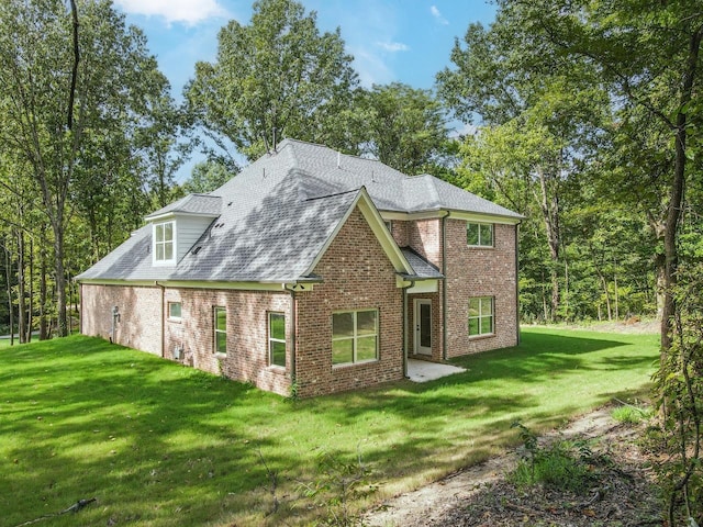 rear view of property with a lawn and a patio