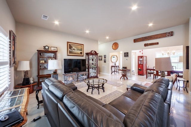 tiled living room featuring a notable chandelier