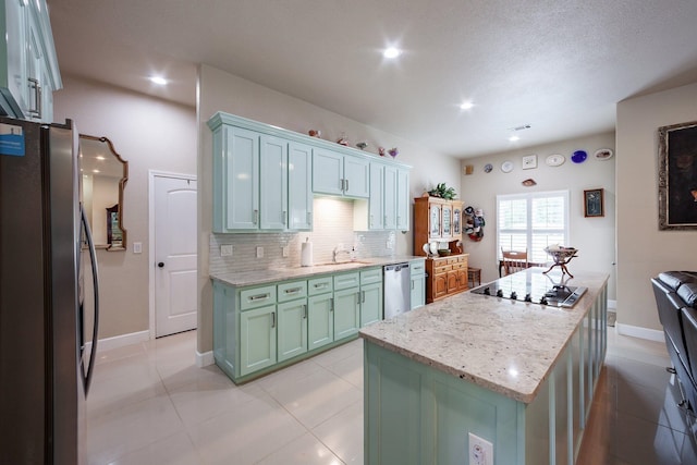 kitchen featuring a textured ceiling, light tile patterned floors, backsplash, a center island, and stainless steel appliances