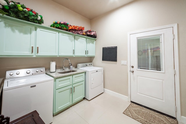 laundry room featuring light tile patterned floors, washer and dryer, cabinets, and sink