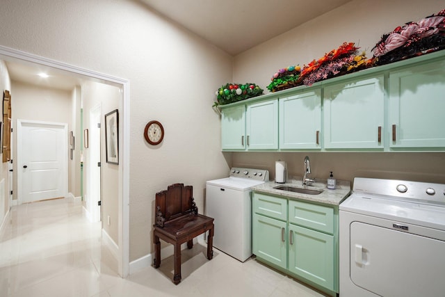 washroom with light tile patterned floors, independent washer and dryer, cabinets, and sink