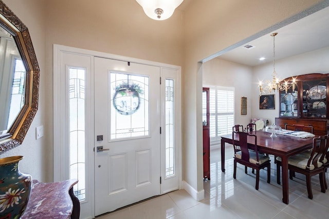 tiled foyer featuring plenty of natural light and a notable chandelier