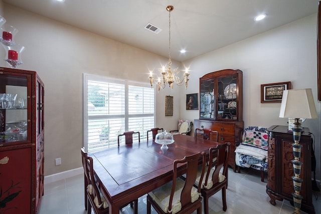 dining area featuring light tile patterned floors and an inviting chandelier