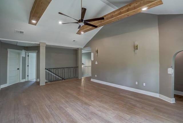 empty room featuring ceiling fan, beamed ceiling, high vaulted ceiling, and hardwood / wood-style flooring